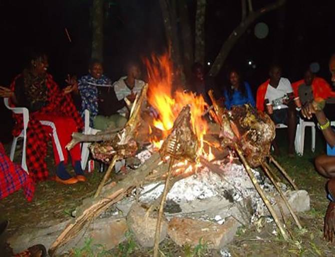 Guests gathered around a bonfire at night
